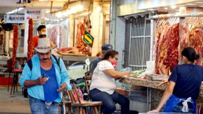 Un consumidor camina entre negocios de carne del Dandy sin la mascarilla.