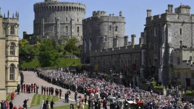 Britain's Prince Harry, Duke of Sussex and his wife Meghan, Duchess of Sussex begin their carriage procession in the Ascot Landau Carriage after their wedding ceremony at St George's Chapel, Windsor Castle, in Windsor, on May 19, 2018. / AFP PHOTO / POOL / TOBY MELVILLE