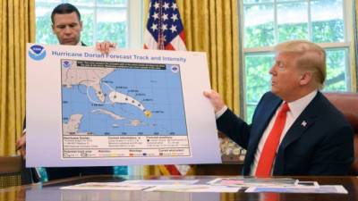 Trump y el secretario de seguridad de EEUU, Kevin McAleenan, mostraron a la prensa un mapa de la trayectoria de Dorian por la costa sureste del país./AFP.