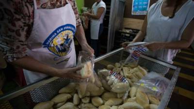 Un grupo de mujeres trabajan empacando bolsas de pan blanco. Foto: Yoseph Amaya