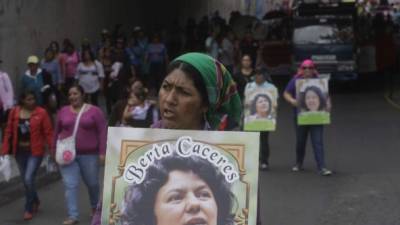 Una mujer indígena lenca sostiene un retrato de la asesinada ambientalista durante una marcha por la capital hondureña para exigir el esclarecimiento del caso.