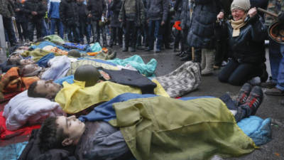 Manifestantes antigubernamentales rodean los cuerpos sin vida de sus compañeros muertos en los enfrentamientos con la policía.