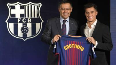 Barcelona's new Brazilian midfielder Philippe Coutinho (R) poses with his new jersey beside Barcelona FC President Josep Maria Bartomeu during his official presentation in Barcelona on January 8, 2018. Philippe Coutinho officially joined Barcelona today, completing a move from Liverpool thought to be worth 160 million euros ($192 million), making it the third richest transfer in history. / AFP PHOTO / LLUIS GENE