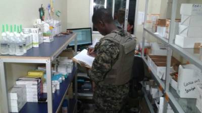 Los militares están haciendo registro de los medicamentos existentes en la farmacia.