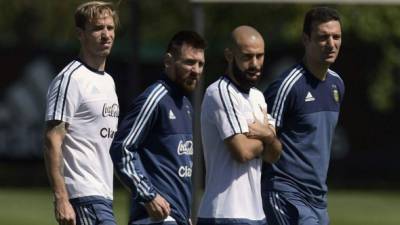Argentina's forward Lionel Messi (2-L) and teammates defender Javier Mascherano (2-R) midfielder Lucas Biglia (L) and a team staffer walk the pitch during a training session in Ezeiza, Buenos Aires on October 6, 2017 ahead of a 2018 FIFA World Cup South American qualifier football match against Ecuador to be held in Quito on October 10. / AFP PHOTO / JUAN MABROMATA