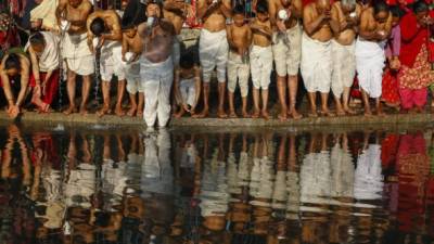 Hombres hindúes toman un baño de masas en el río Hanumante durante el festival Madhav Narayan en Bhaktapur, Nepal, este 2 de enero.