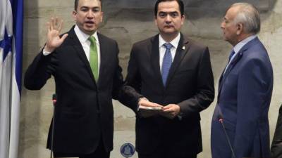 El nuevo presidente de la Corte Suprema de Justicia de Honduras, Rolando Argueta, durante su juramentación ante el secretario del Congreso, Mario Pérez, y el presidente del Legislativo, Mauricio Oliva.
