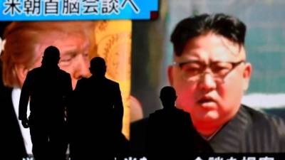 Varias personas pasan delante de una pantalla gigante con la imagen del presidente de EE.UU., Donald J. Trump (i), y del líder norcoreano, Kim Jong-un, hoy en Tokio. EFE