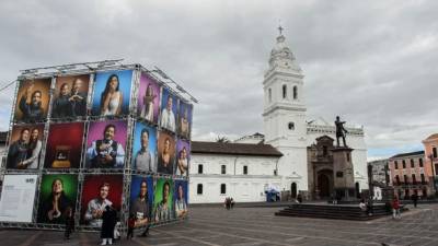 Transeúntes observan una exposición de retratos en la plaza de Santo Domingo en el centro histórico de Quito. Fotos: EFE