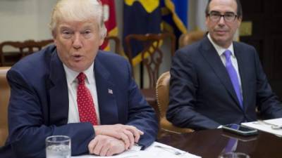 Donald Trump en una reunión de gabinete, flanqueado por Steve Mnuchin, su secretario del Tesoro