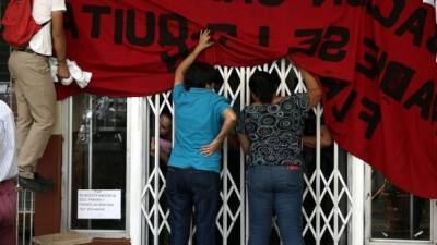 Los estudiantes del Reyes colocan una manta de protesta en la entrada de la Departamental. Foto: Yoseph Amaya