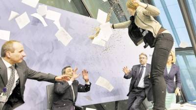 La intervención de Mario Draghi fue interrumpida por una manifestante que se lanzó contra el escritorio del banquero central y gritó “fin a la dictadura del BCE”.