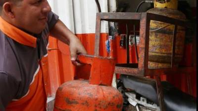 Un empleado de una estación de servicio de San Pedro Sula verifica un cilindro. Foto: Amílcar Izaguirre.