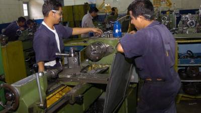 Estudiantes del Instituto Nacional de Formación Profesional (Infop) trabajan en una maquinaria.