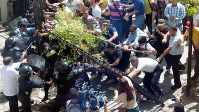 En un hecho inédito e insólito un grupo de manifestantes de Libre que apoyan al periodista David Romero rompieron un portón para entrar a la sala de juicios y sacar al enjuiciado.