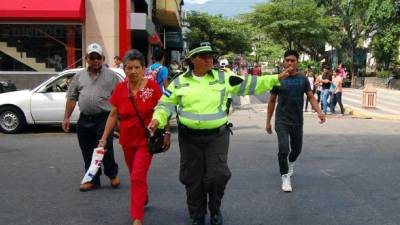 Como una de sus labores, los Amigos de Tránsito también ayudan a las personas a cruzar las calles.