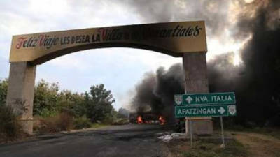 Un autobús arde cerca de Paracuaro en la carretera entre Apatzingán y Cuatro Caminos en el Estado de Michoacán el 10 de enero del 2014. Foto Cortesía de PrensaLibre.com