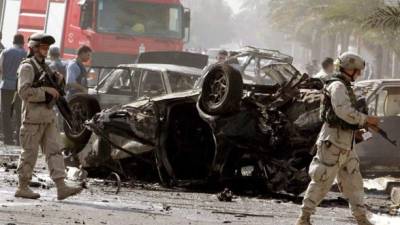 Unos soldados estadounidenses inspeccionan el lugar en el que explotó un coche bomba conducido por un suicida junto a un control en el barrio de al-Karadah, Bagdad, Irak, El sábado 24 de septiembre de 2005. EFE/Mohamed Messara/Archivo.