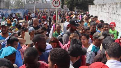 Los migrantes hacen fila por varias horas para obtener un permiso humanitario para transitar por México.