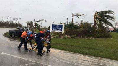 TOPSHOT - In this image courtesy of US Coast Guard (USCG), Coast Guard personnel help medevac a patient from the Marsh Harbour Healthcare Center in the Bahamas on September 3, 2019, during Hurricane Dorian. - Dorian churned towards the United States Wednesday after leaving seven dead in the Bahamas, where the prime minister said terrified residents had endured 'days of horror' at the hands of the monster storm. Announcing the updated death toll, Prime Minister Hubert Minnis warned the number would rise as he called Dorian 'one of the greatest national crises in our country's history.' (Photo by Brandon Murray / US Coast Guard / AFP) / RESTRICTED TO EDITORIAL USE - MANDATORY CREDIT 'AFP PHOTO / US COAST GUARD/ Petty Officer 3rd Class Brandon Murray' - NO MARKETING NO ADVERTISING CAMPAIGNS - DISTRIBUTED AS A SERVICE TO CLIENTS