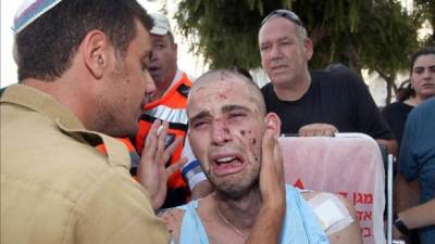 El soldado Gal Ganon llora a su llegada al funeral de su compañero de tropa Avi Greentzweig, en el cementerio de Petah Tikva, afueras de Tel Aviv. EFE