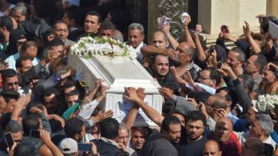 Coptic Christians carry the coffins of victims killed in an attack a day earlier,following a morning ceremony at the Prince Tadros church in Egypt's southern Minya province, on November 3, 2018. - Gunmen attacked a bus carrying Coptic Christians in central Egypt yesterday, killing seven in the latest assault on the religious minority claimed by the Islamic State (IS) group.The attackers opened fire on the bus of pilgrims in Minya province after the occupants had visited the Saint Samuel monastery, the local bishop told AFP. (Photo by MOHAMED EL-SHAHED / AFP)