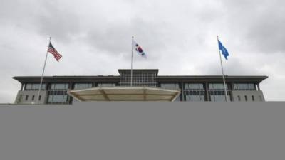 Banderas de EE. UU. (L), surcoreano (C) y ONU (R) revolotean sobre el nuevo cuartel general del Comando de las Naciones Unidas y las Fuerzas estadounidenses Corea durante una gran ceremonia de inauguración del edificio. Foto: AFP