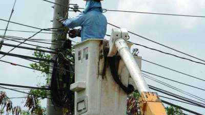 Empleado de la Enee trabaja en un poste de luz.