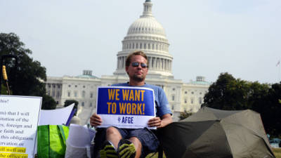 A protester displays a placard as he joins others in a demonstration in front of the US Capitol in Washington, DC, October 3, 2013, urging congress to end the federal government shutdown. The political crisis gripping Washington could trigger a 'catastrophic' US debt default, the Treasury warned Thursday, as America limped into day three of a government shutdown. Despite the looming danger to the US and world economies, there was no sign that either President Barack Obama or his Republican foes were ready to give ground. AFP Photo/Jewel Samad