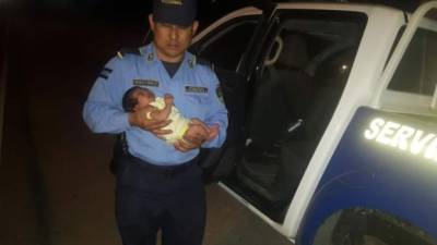 Un agente policial cargando a la bebé en el momento de su rescate.