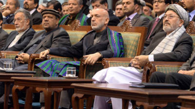 Afghan President Hamid Karzai attends the Afghan loya jirga, a meeting of around 2,500 Afghan tribal elders and leaders, on the last day of the four-day long loya jirga in Kabul on November 24, 2013. An Afghan grand assembly endorsed a crucial security agreement allowing some US troops to stay on after 2014, although President Hamid Karzai set conditions for signing the deal. AFP PHOTO/Massoud HOSSAINI
