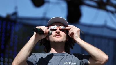 David Weigel, director del Planetario INTUITIVO del Centro Espacial y de Cohetes de EE. UU., demuestra cómo usar gafas de eclipse para el próximo eclipse solar del 8 de abril.