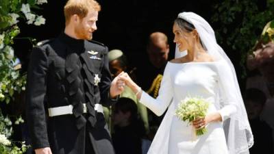 Britain's Prince Harry, Duke of Sussex and his wife Meghan, Duchess of Sussex emerge from the West Door of St George's Chapel, Windsor Castle, in Windsor, on May 19, 2018 after their wedding ceremony. / AFP PHOTO / POOL / Ben Birchall