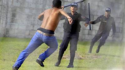 Un aficionado de Motagua trata de esquivar a los policías.