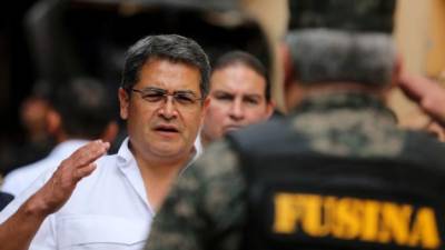 El presidente de Honduras, Juan Orlando Hernández, saluda a un jefe militar en el cierre del penal de Santa Bárbara, el segundo clausurado en el país para frenar los índices de criminalidad.