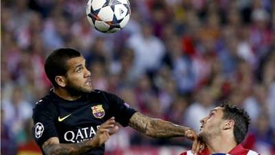 Dani Alves lucha por el balón con Koke durante el partido en el Calderón.