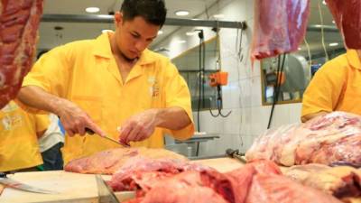 Un carnicero corta pollo en uno de los puestos del mercado Dandy. Foto: Franklin Muñoz.