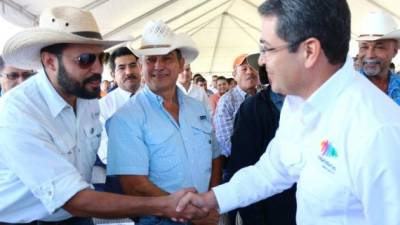 El presidente de Honduras, Juan Orlando Hernández, saluda a un ganadero durante la firma del convenio.