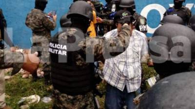 Elementos de la Policía Militar mientras revisan a los pandilleros recluidos en el Centro Penal de San Pedro Sula previo a ser trasladados.