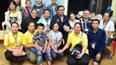 El primer ministro tailandés, Prayut Chan-o-cha (c), posa junto a familiares de los jugadores de fútbol rescatados en una cueva de Tham Luang, en la provincia de Chiang Rai (Tailandia). EFE