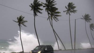 Un vehículo transita cerca a la playa que presenta oleaje fuerte el jueves 21 de septiembre tras el paso del huracán María en Santo Domingo, República Dominicana. EFE