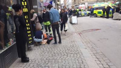 An injured person is helped at the scene where a truck crashed into the Ahlens department store at Drottninggatan in central Stockholm, April 7, 2017. / AFP PHOTO / TT News Agency / Rose-Marie Otter / Sweden OUT