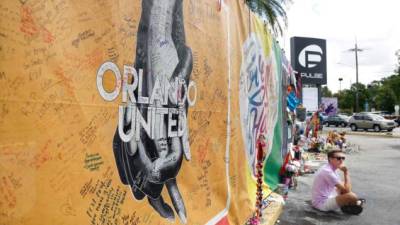 ORLANDO, FL - JUNE 12: Dave Morales (L) and Leigh Fannin hold hands as they attend the one-year anniversary memorial service for victims of the mass shooting at the Pulse gay nightclub on June 12, 2017 in Orlando, Florida. Omar Mateen killed 49 people and wounded 53 before being killed himself by police in a shootout at the club a little after 2 a.m. on June 12, 2016. Joe Raedle/Getty Images/AFP== FOR NEWSPAPERS, INTERNET, TELCOS & TELEVISION USE ONLY ==