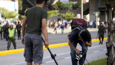 El fotógrafo de Agencia Efe Luis Eduardo Noriega (d) recibe un golpe de un policía vestido de civil (i) hoy, jueves 29 de agosto de 2013, en Medellín (Colombia).