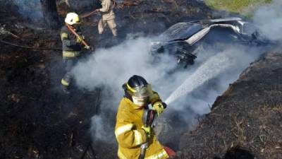 Los bomberos apagan el fuego en el vehículo.