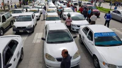 Conductores de taxis parquean sus unidades en una vía en el bulevar del norte de San Pedro Sula.