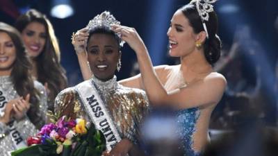 Catriona Gray coloca la corona a Miss Sudáfrica, Zozibini Tunzi. Foto: AFP