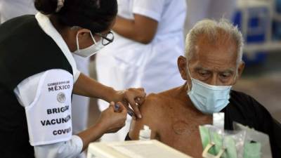 An elderly man receives a dose of the CoronaVac vaccine against COVID-19 at a vaccination center in Acapulco, Guerrero state, Mexico, on March 19, 2021. (Photo by ALFREDO ESTRELLA / AFP)