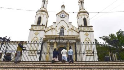 Mujeres arrodilladas frente a la basílica menor de Nuestra Señora de Suyapa ayer, víspera de la conmemoración del Día de la Virgen Suyapa, Patrona de Honduras.(Photo by Orlando SIERRA / AFP)