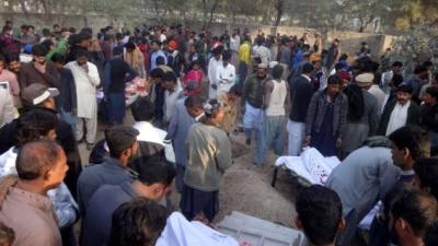 Cristianos paquistaníes se reúnen en un cementerio para una ceremonia fúnebre por las muertes por licores tóxicos la víspera de Navidad en una colonia cristiana. AFP